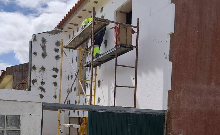 Fachada de moradia com placas de isolamento térmico (capoto) aplicadas e pontos de fixação à vista