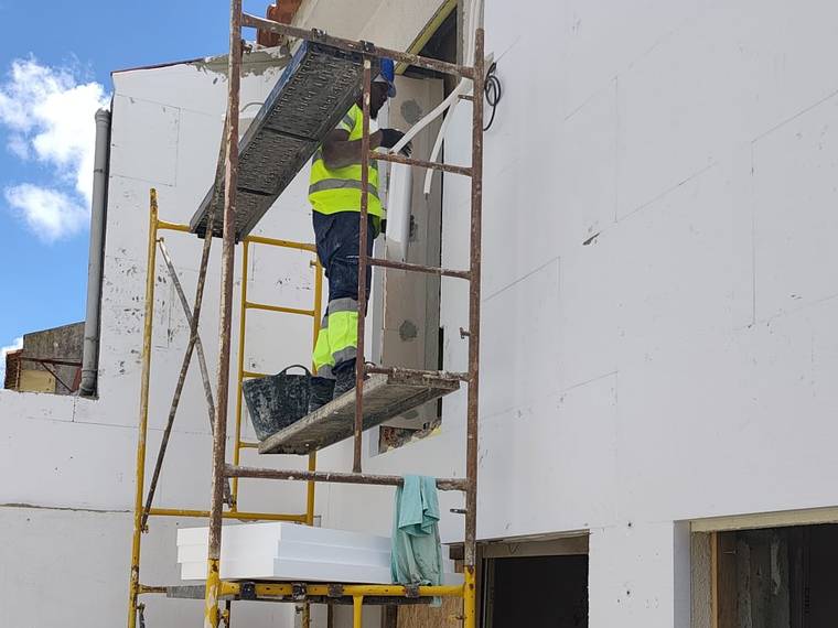 Aplicação de capoto numa fachada, com a equipa MUTTA a trabalhar em andaime