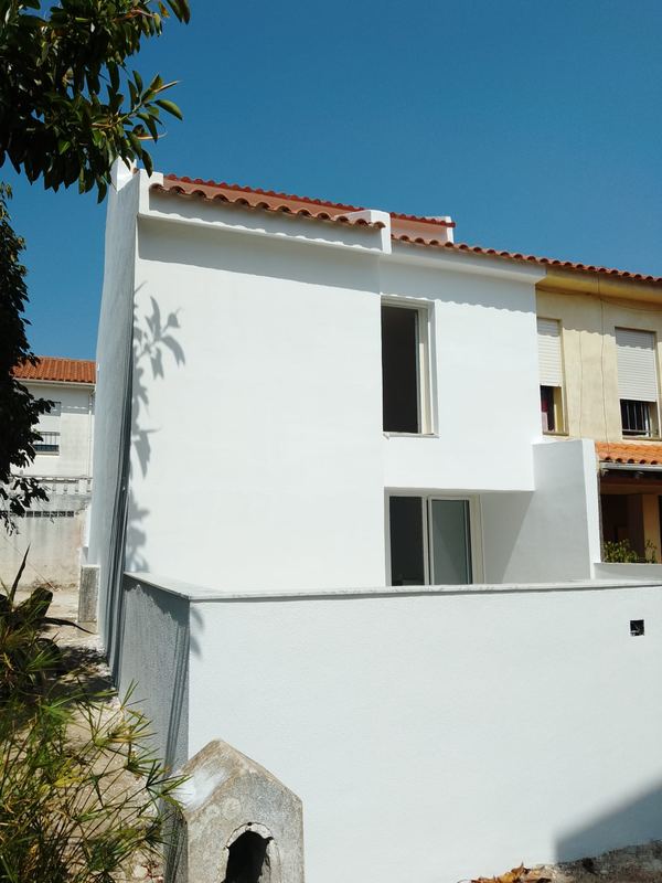 Moradia renovada: vista lateral com muro de vedação